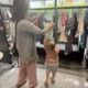 Mum and child browsing a rail of clothes at a clothes swap